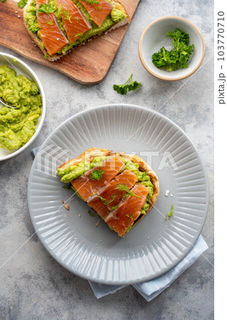 Toast with salmon, guacamole avocado and herbs. Healthy food. Top view. Toast with salmon, guacamole avocado and herbs. Healthy food. Top view. 103770710
