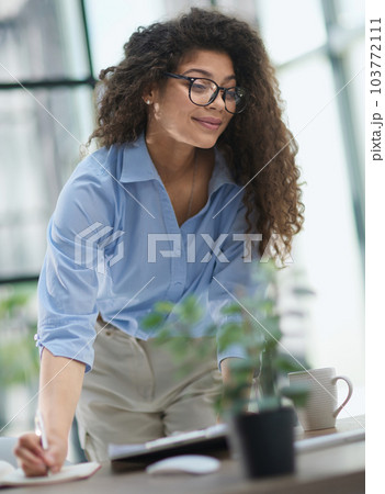 woman makes a report in the office. Woman writing notes for educational project in business 103772111