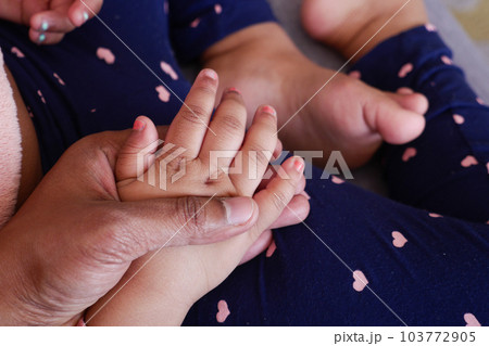 father holding hand of baby child, close up . father holding hand of baby child, close up . 103772905