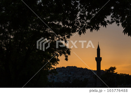 トルコ　シャンルウルファの夕焼けに染まった空とモスクのミナレットのシルエット 103776488