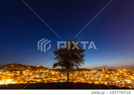 トルコ　シャンルウルファの丘の上に立つ一本の木と旧市街の夜景と星空 103776516