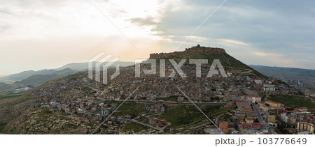 トルコ 丘から見えるマルディンの旧市街の街並みと山頂に立つマルディン城と夕焼け空 トルコ 丘から見えるマルディンの旧市街の街並みと山頂に立つマルディン城と夕焼け空 103776649