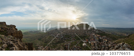トルコ　丘から見えるマルディンの旧市街の街並みと山頂に立つマルディン城と夕焼け空 103776655