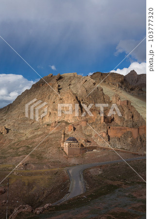 トルコ　山腹の上に建つドゥバヤジット城と後ろに聳える断崖絶壁の岩山 103777320