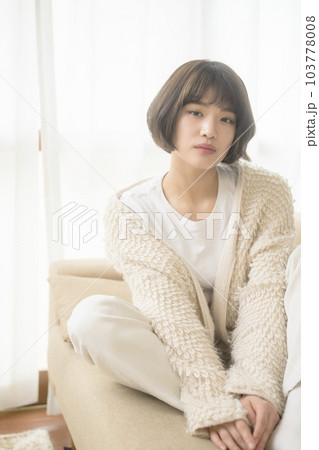 ソファでくつろぐ若い女性（ブラックミストフィルター） 103778008