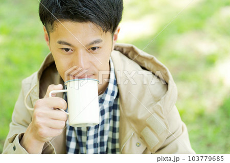 屋外でコーヒーを飲む男性の写真 103779685