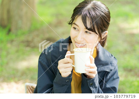 屋外でコーヒーを飲む女性の写真 103779719
