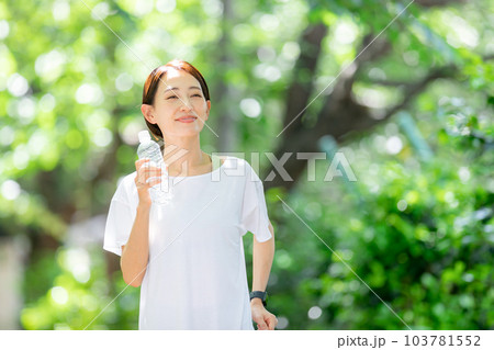 水を持ってジョギングする女性 初夏 新緑 水を持ってジョギングする女性 初夏 新緑 103781552