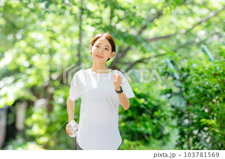 水を持ってジョギングする女性 初夏 新緑 水を持ってジョギングする女性 初夏 新緑 103781569