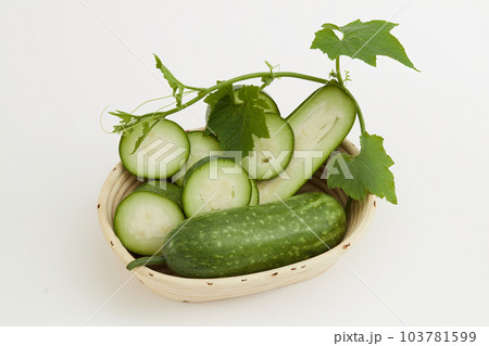A beige basket containing slices of winter melon and leaf placed on white background. Advertising scene for product with winter melon ingredient. A beige basket containing slices of winter melon and leaf placed on white background. Advertising scene for product with winter melon ingredient. 103781599
