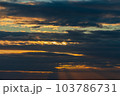 The sun's light gilds the dark storm clouds at dawn 103786731