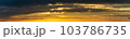 The sun's light gilds the dark storm clouds at dawn 103786735
