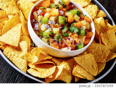 summer fruit salsa with tortilla chips on plate 103787249