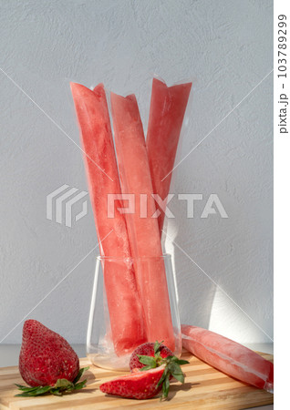 Ice cream in a bag with strawberries, sweet frozen homemade. Brazilian Dindin, geladinho or Sokole. Ice cream in a bag with strawberries, sweet frozen homemade. Brazilian Dindin, geladinho or Sokole. 103789299