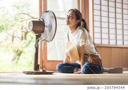 扇風機で涼む女性の写真素材 [103794344] - PIXTA