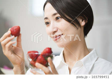 イチゴを食べる若い女性　飲食イメージ	 103799451