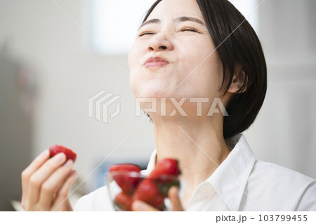 イチゴを食べる若い女性　飲食イメージ	 103799455