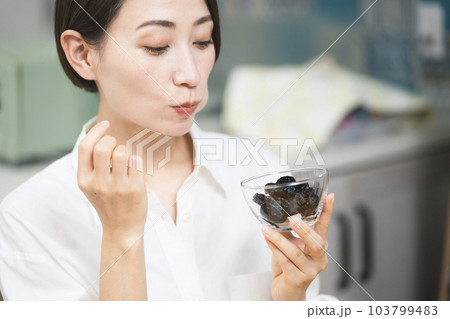 プルーンを食べる若い女性　飲食イメージ 103799483