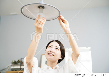 電球の交換をする若い女性　ライフタイルイメージ	 103799516