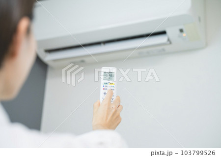 エアコンを操作する若い女性 ライフスタイルイメージ エアコンを操作する若い女性 ライフスタイルイメージ 103799526