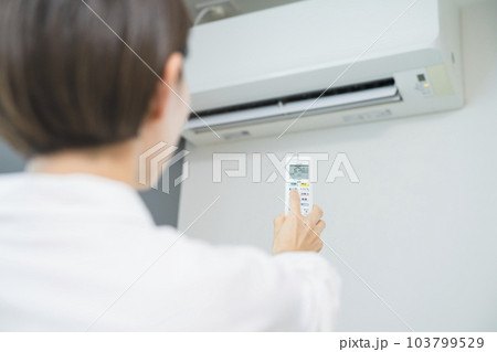 エアコンを操作する若い女性 ライフスタイルイメージ エアコンを操作する若い女性 ライフスタイルイメージ 103799529