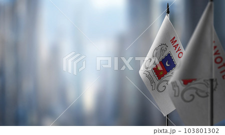Small flags of the Mayotte on an abstract blurry background Small flags of the Mayotte on an abstract blurry background 103801302