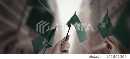 A group of people holding small flags of the Macao in their hands 103801363