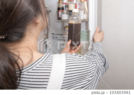 【冷蔵室からソースを出す主婦】 103803991