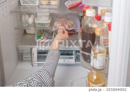 【冷蔵室から唐揚用の下味を付けた鶏肉を出す主婦】 【冷蔵室から唐揚用の下味を付けた鶏肉を出す主婦】 103804002
