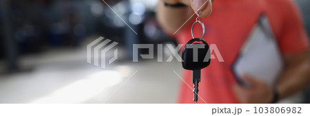 Person mechanic handing over key to car in workshop Person mechanic handing over key to car in workshop 103806982