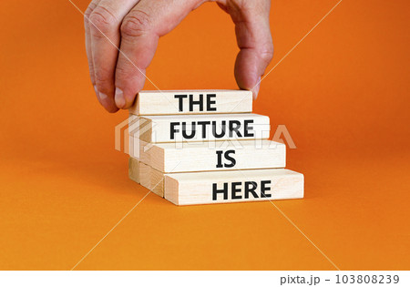 The future is here symbol. Concept words The future is here on wooden block. Beautiful orange table orange background. Businessman hand. Motivational business the future is here concept. Copy space. The future is here symbol. Concept words The future is here on wooden block. Beautiful orange table orange background. Businessman hand. Motivational business the future is here concept. Copy space. 103808239