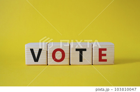 Vote symbol. Concept word Vote on wooden cubes. Beautiful yellow background. Business and Vote concept. Copy space. Vote symbol. Concept word Vote on wooden cubes. Beautiful yellow background. Business and Vote concept. Copy space. 103810047
