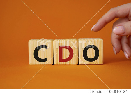 CDO - Collateralized Debt Obligation symbol. Wooden cubes with word CDO. Beautiful orange background. Businessman hand. Business and Collateralized Debt Obligation concept. Copy space. CDO - Collateralized Debt Obligation symbol. Wooden cubes with word CDO. Beautiful orange background. Businessman hand. Business and Collateralized Debt Obligation concept. Copy space. 103810184