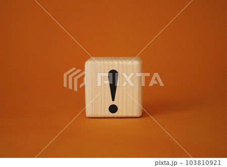 Exclamation mark symbol. Exclamation mark on wooden cubes. Beautiful orange background. Business and Exclamation mark concept. Copy space. 103810921