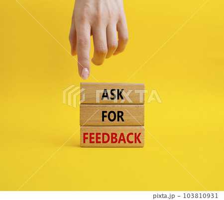 Feedback symbol. Concept word Ask for feedback on wooden blocks. Businessman hand. Beautiful yellow background. Business and Ask for feedback concept. Copy space 103810931