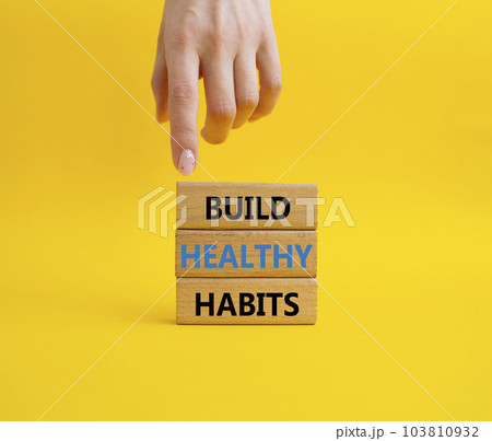 Healthy habits symbol. Concept word Build Healthy habits on wooden blocks. Doctor hand. Beautiful yellow background. Healthy lifestyle and Healthy habits concept. Copy space 103810932