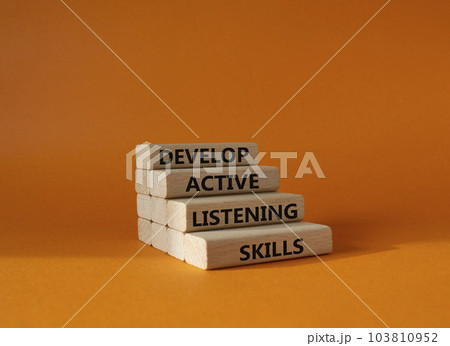 Listening skills symbol. Concept word Develop active listening skills on wooden blocks. Beautiful orange background. Business and Develop active listening skills concept. Copy space Listening skills symbol. Concept word Develop active listening skills on wooden blocks. Beautiful orange background. Business and Develop active listening skills concept. Copy space 103810952