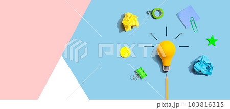 Brainstorming concept with a light bulb and school supplies - Flat lay Brainstorming concept with a light bulb and school supplies - Flat lay 103816315