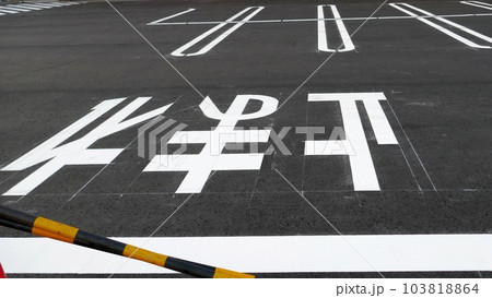 駐車場に描かれた白線や注意喚起の文字 駐車場に描かれた白線や注意喚起の文字 103818864