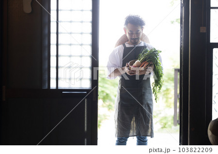 古民家に採れたて野菜を持ってくる農家の人　シルエット 103822209