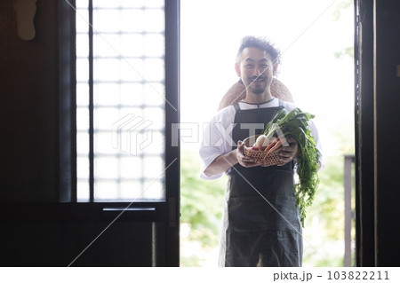 古民家に採れたて野菜を持ってくる農家の人のシルエット　カメラ目線 103822211