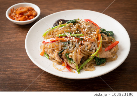 japchae or stir-fried Korean vermicelli noodles with vegetables and pork topped with white sesame 103823190