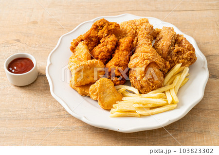 fried chicken with french fries and nuggets on plate fried chicken with french fries and nuggets on plate 103823302