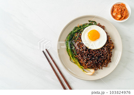 dried Korean spicy black sauce instant noodles with fried egg and kimchi 103824976