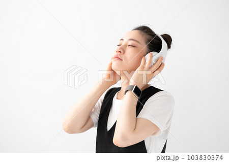 ヘッドフォンで音楽を聴く女性 103830374
