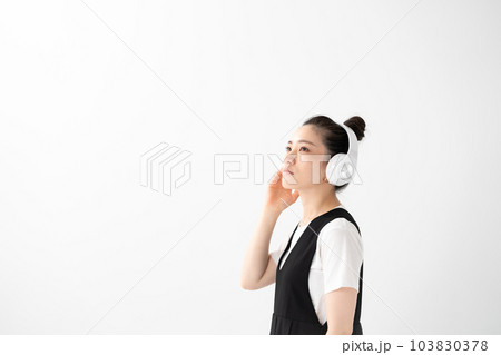ヘッドフォンで音楽を聴く女性 103830378