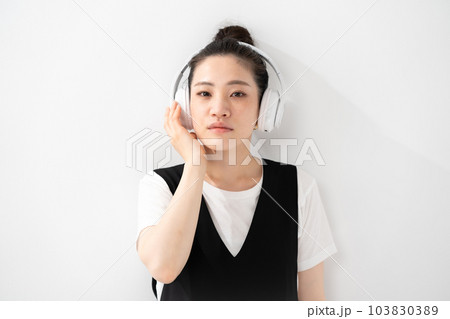 ヘッドフォンで音楽を聴く女性 103830389