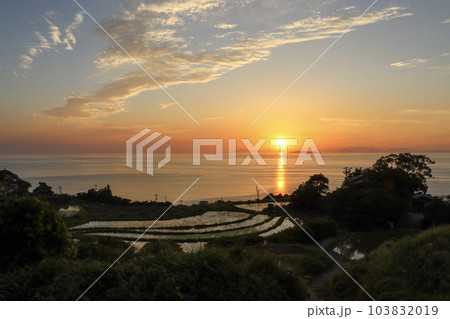 オレンジ色の夕焼け空に沈む夕日と棚田 オレンジ色の夕焼け空に沈む夕日と棚田 103832019