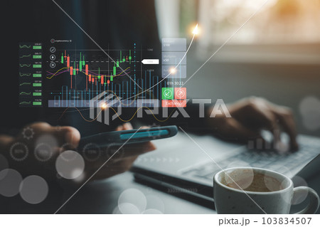 Businessman checking stock market trends and currency exchange rates on laptop and mobile phone. Economic growth and finance concept. checking stock market graph report analysis 103834507