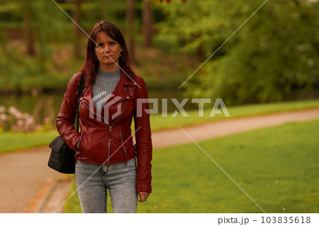 Hipster girl in leather jacket in the park Hipster girl in leather jacket in the park 103835618